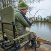 Angler fishing while sitting in Korum S23 Deluxe Accessory Chair