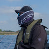 Male angler on a boat wearing a life jacket and 'Agitator' branded Snood with a lake and sky background.